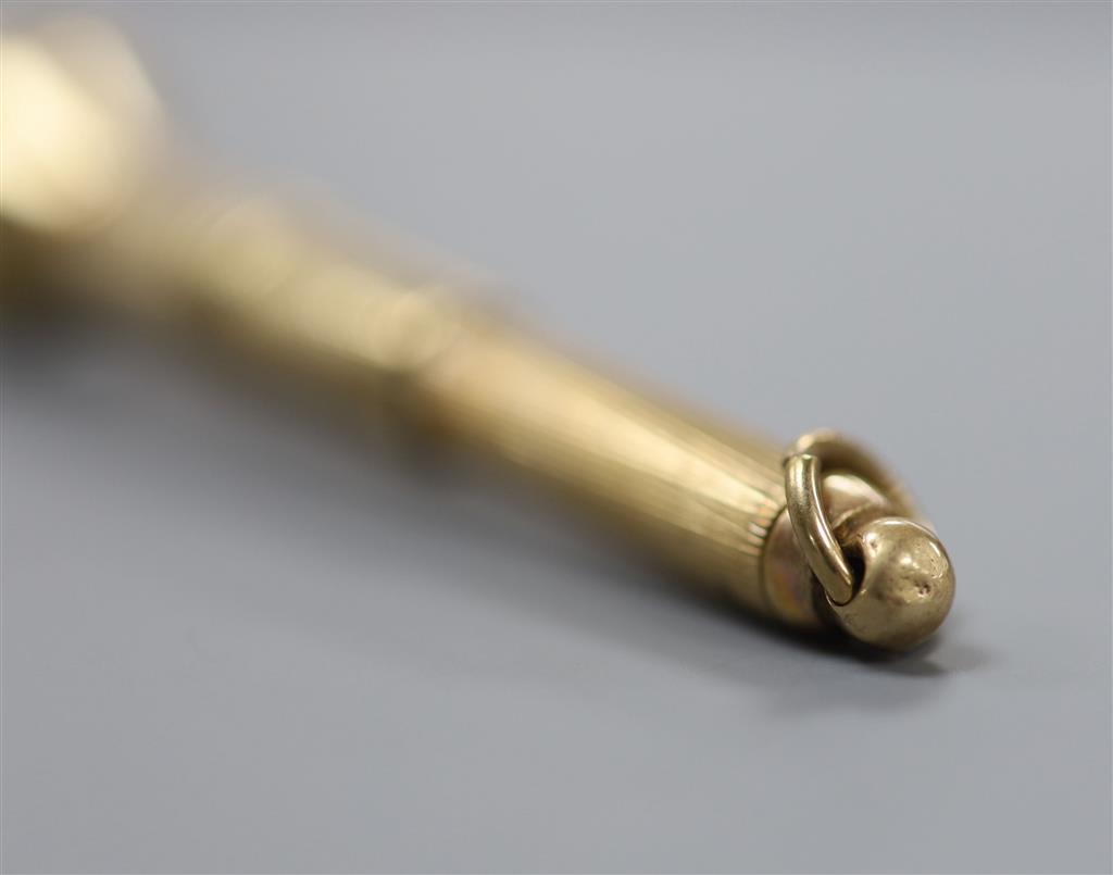 A mi 20th century engine turned 9ct gold cased cigar piercer, 67mm, gross 8.6 grams.